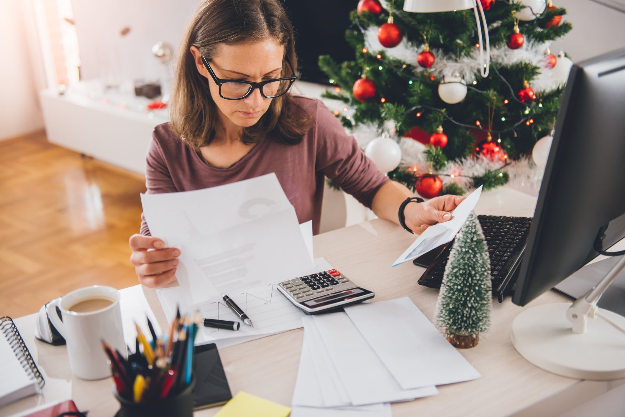 women working with mini Christmas tree on desk