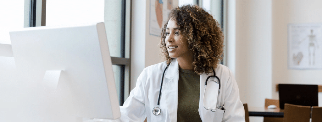 Female doctor in white coat working on computer.